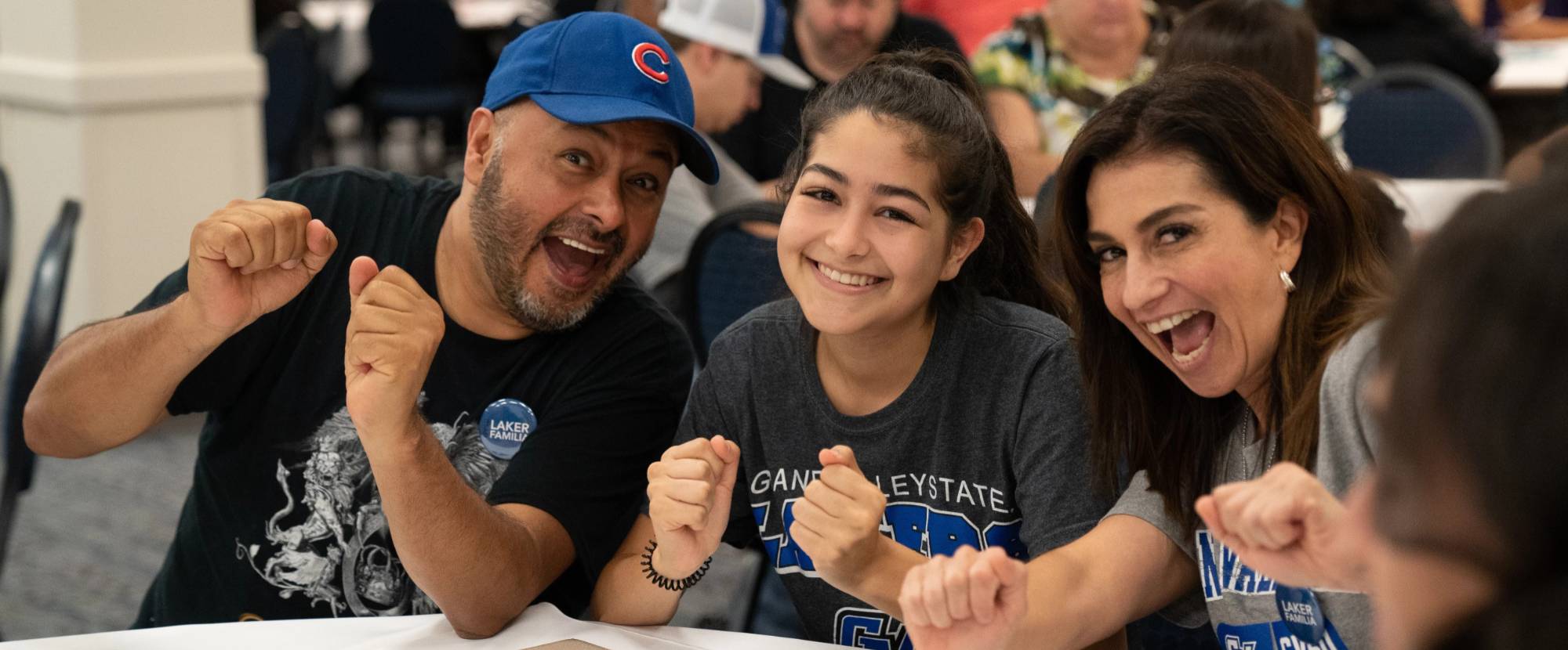 Student sitting with parents smiling